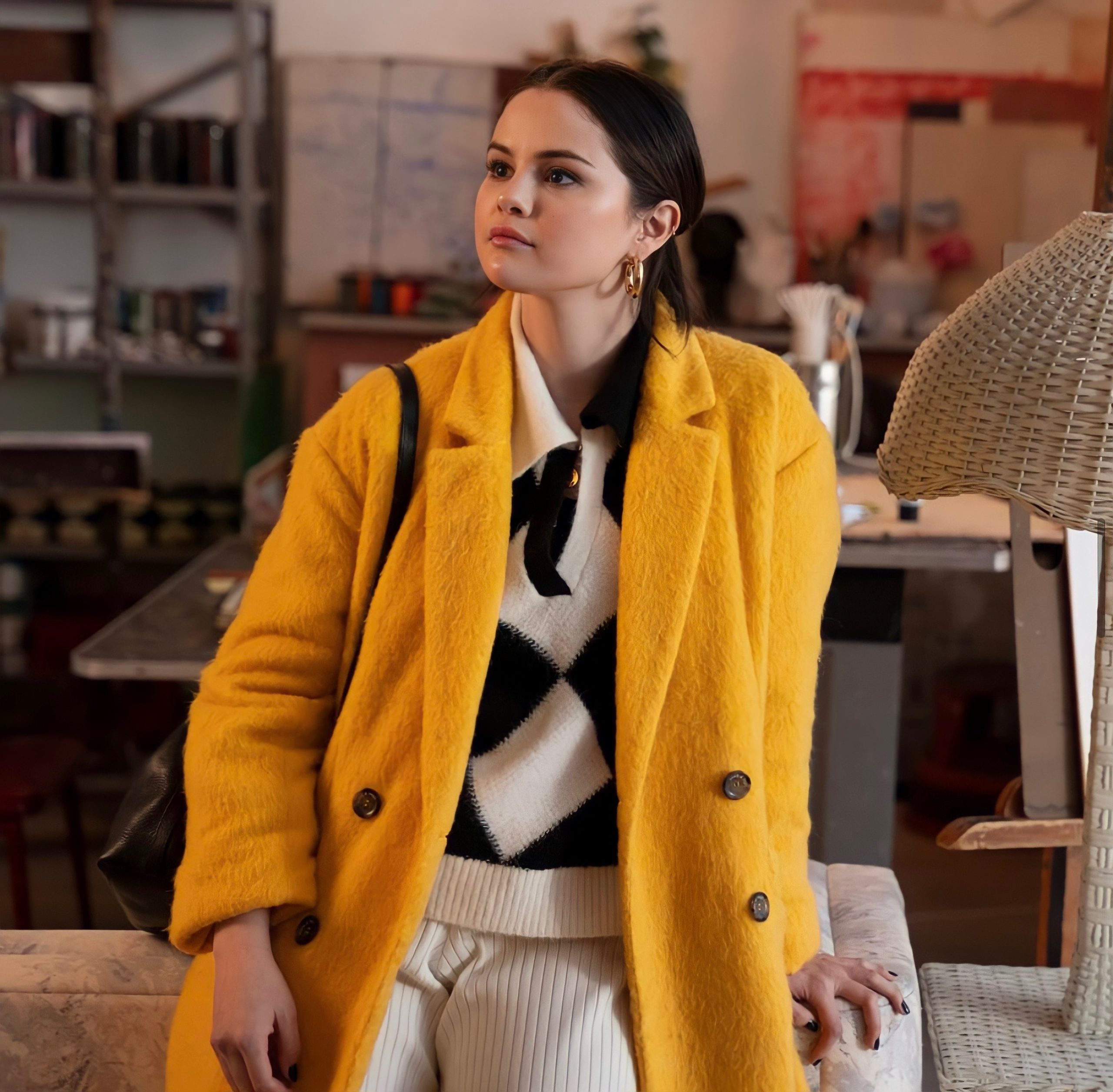 Selena Gomez wearing yellow coat by Cinq a Sept and black and white harlequin sweater by & Other Stories in Only Murders in the Building