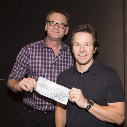 Mark Wahlberg recieving the check from the President of the HFPA, Theo Kingma
