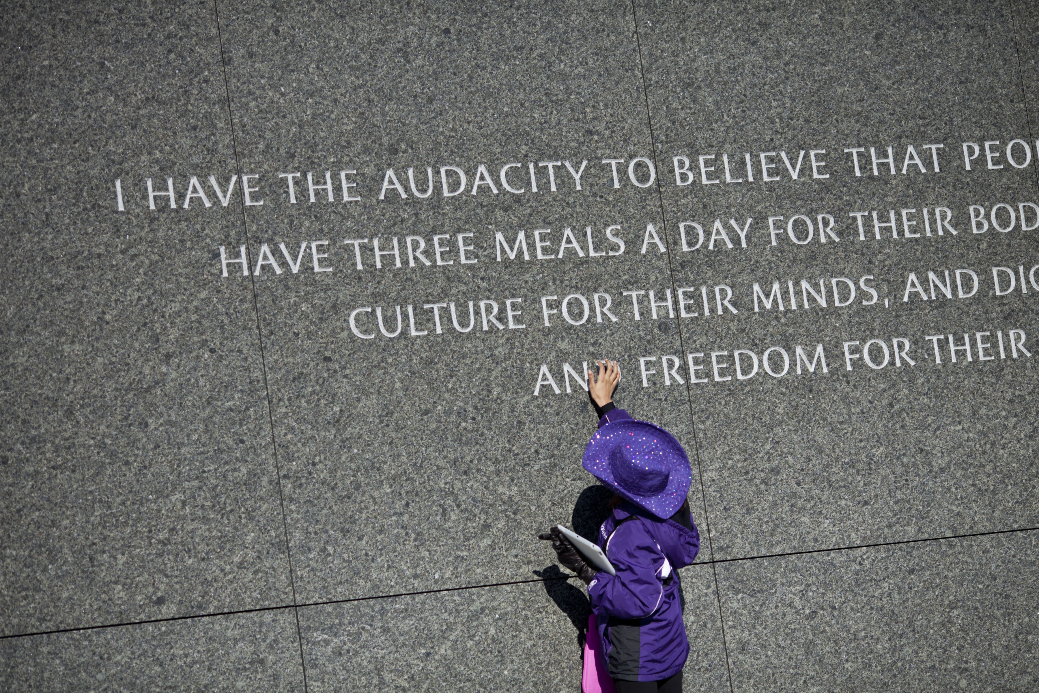 A girl looks at a quote at the Martin Luther King Jr. memorial on the National Mall January 15, 2012 in Washington, DC.